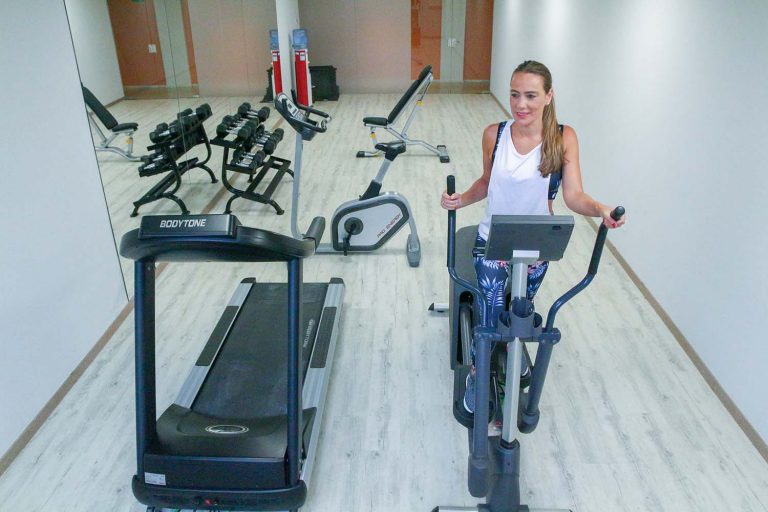 mujer en máquina elíptica haciendo ejercicio