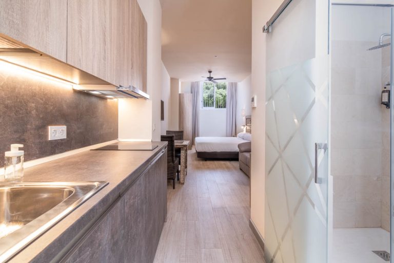 baño y cocina en apartamento turístico con cama al fondo