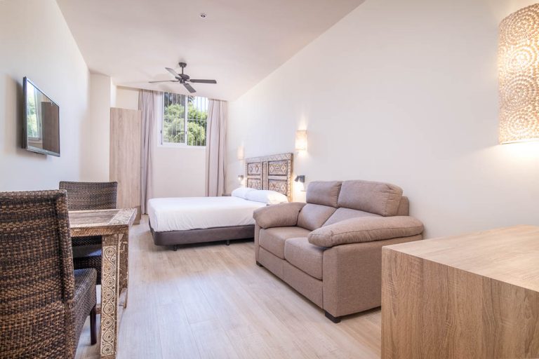 apartamento turístico con cama doble, televisión, sofá y mesa en tarifa